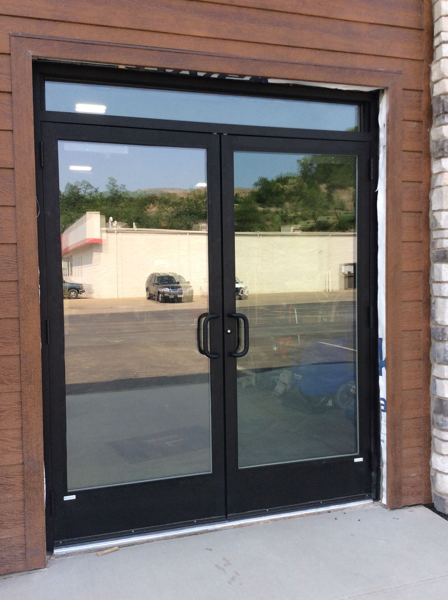 Black framed double glass doors with a glass transom.