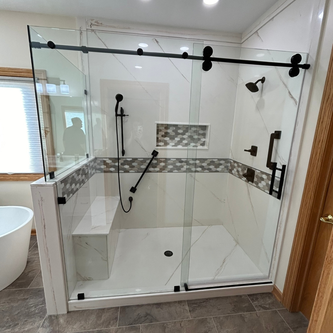 A bathroom with a sliding glass shower door and a tub.