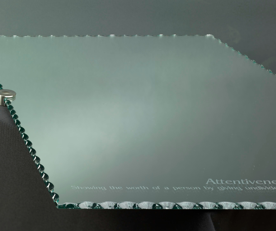 A piece of glass that says attention on it