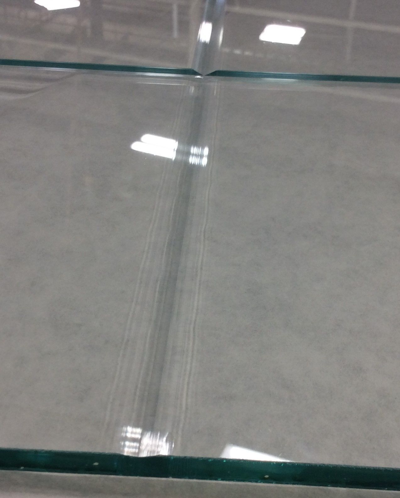A piece of glass is sitting on a concrete floor.
