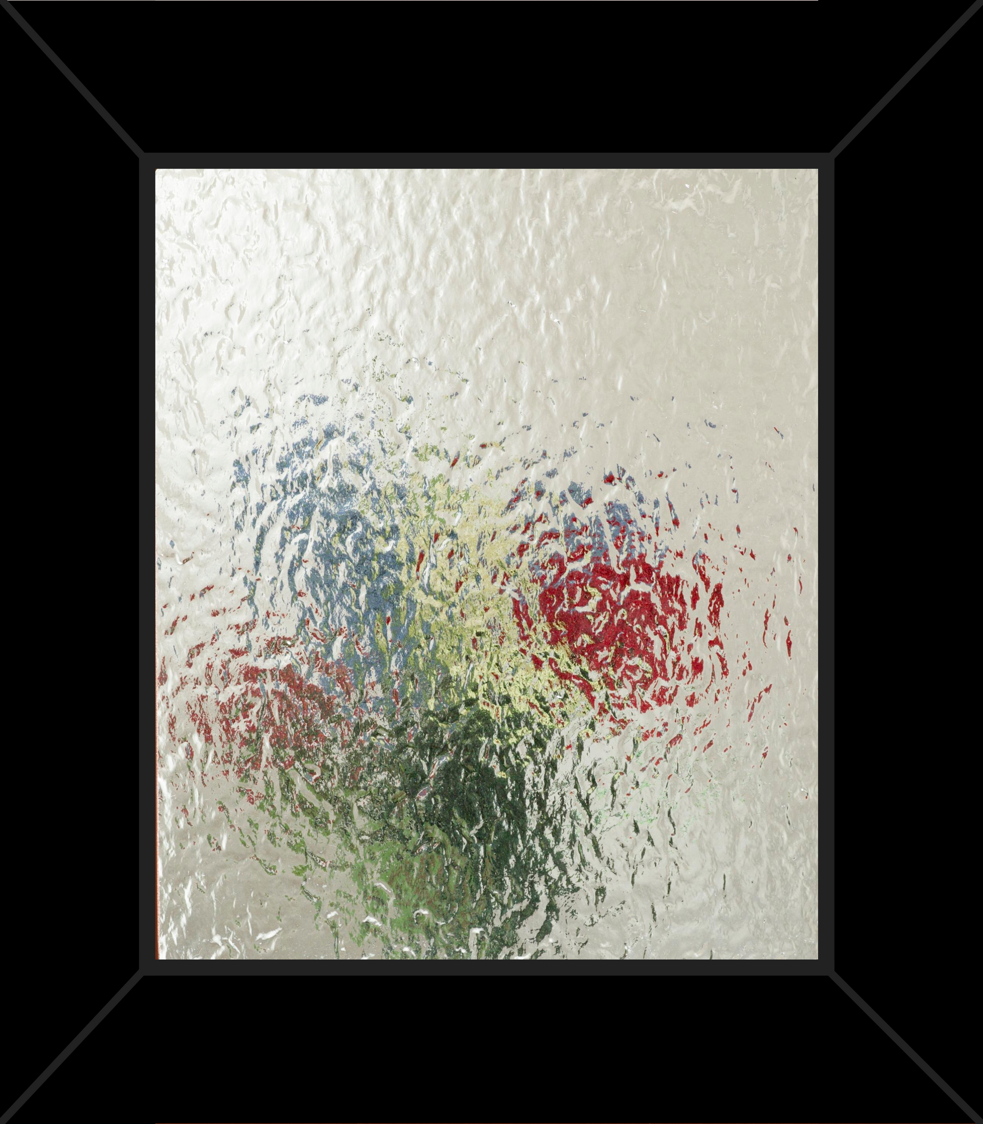A picture of flowers on a glass wall in a black frame.