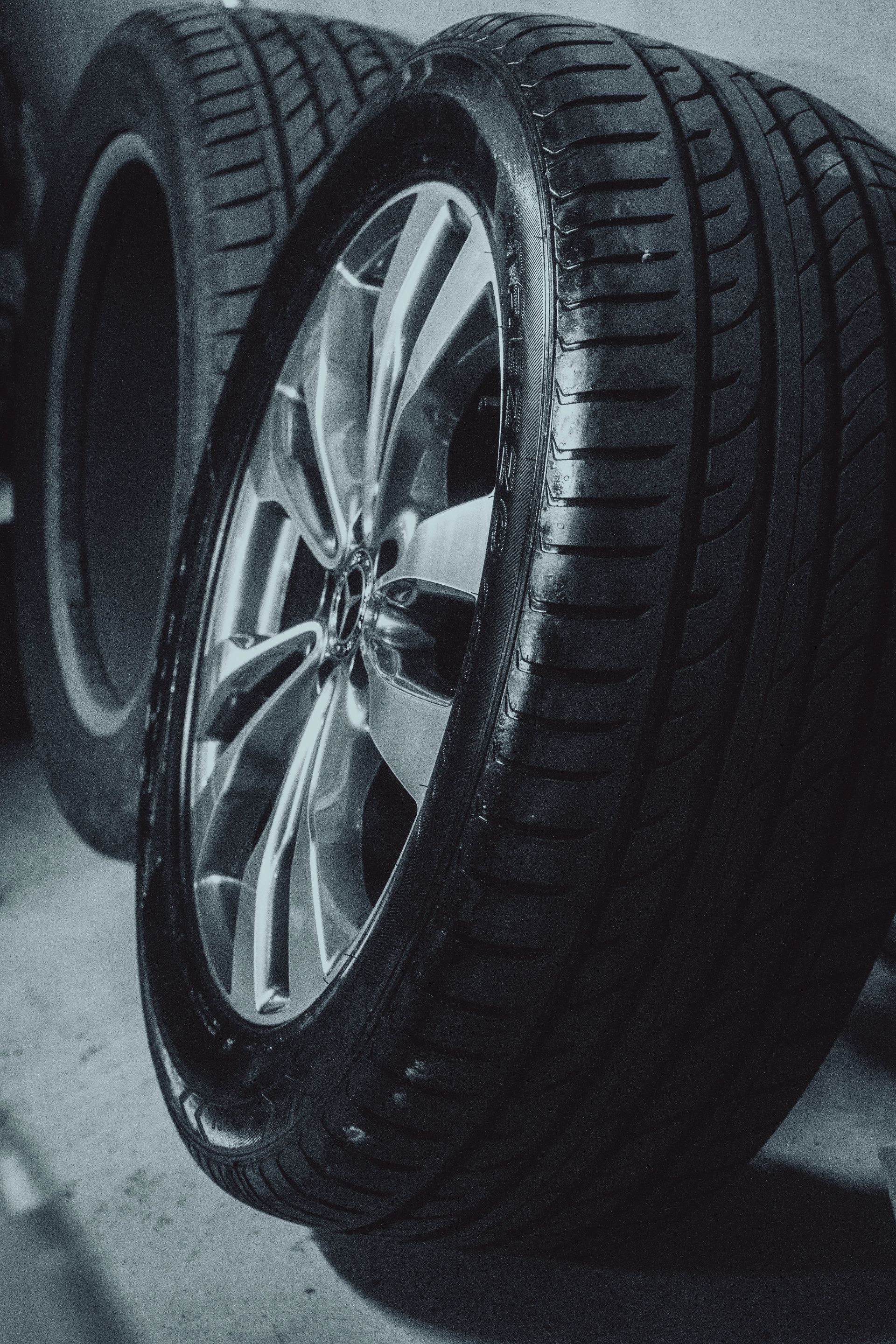 Two tires are stacked on top of each other in a garage.