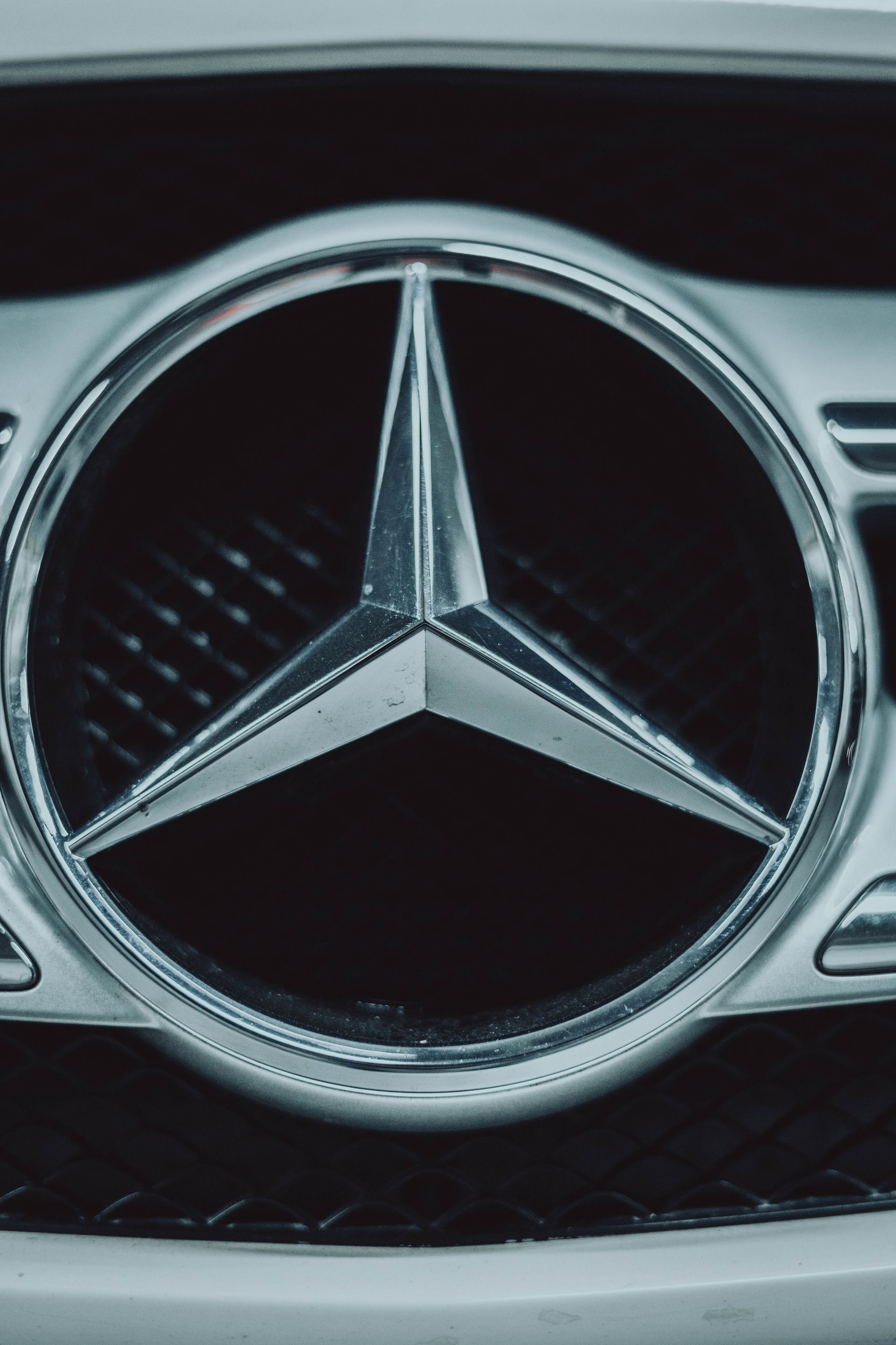 A close up of a mercedes benz logo on the front of a car