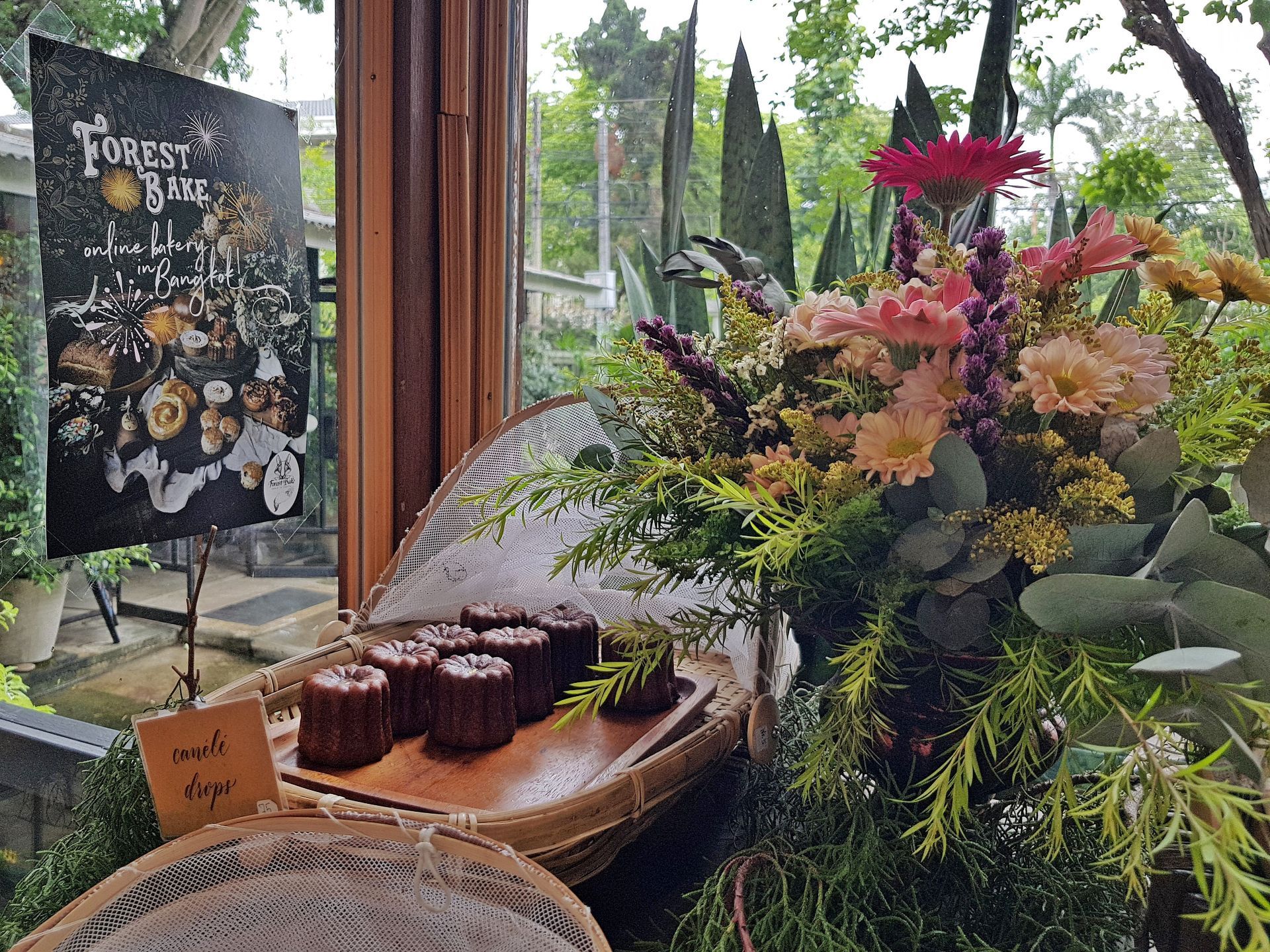 A bunch of flowers are sitting on a table in front of a window.