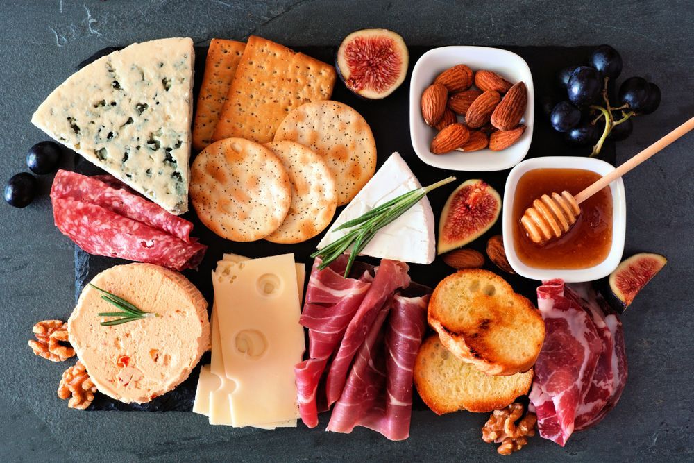 There are many different types of food on the cutting board.