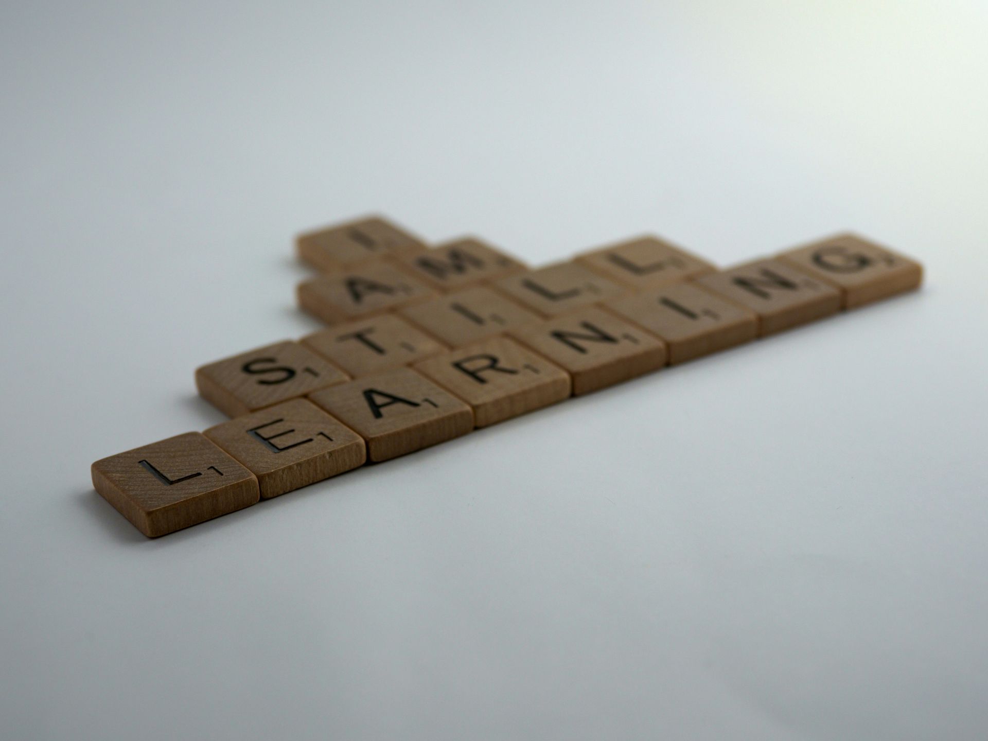 Scrabble tiles arranged on a white surface to spell the words 