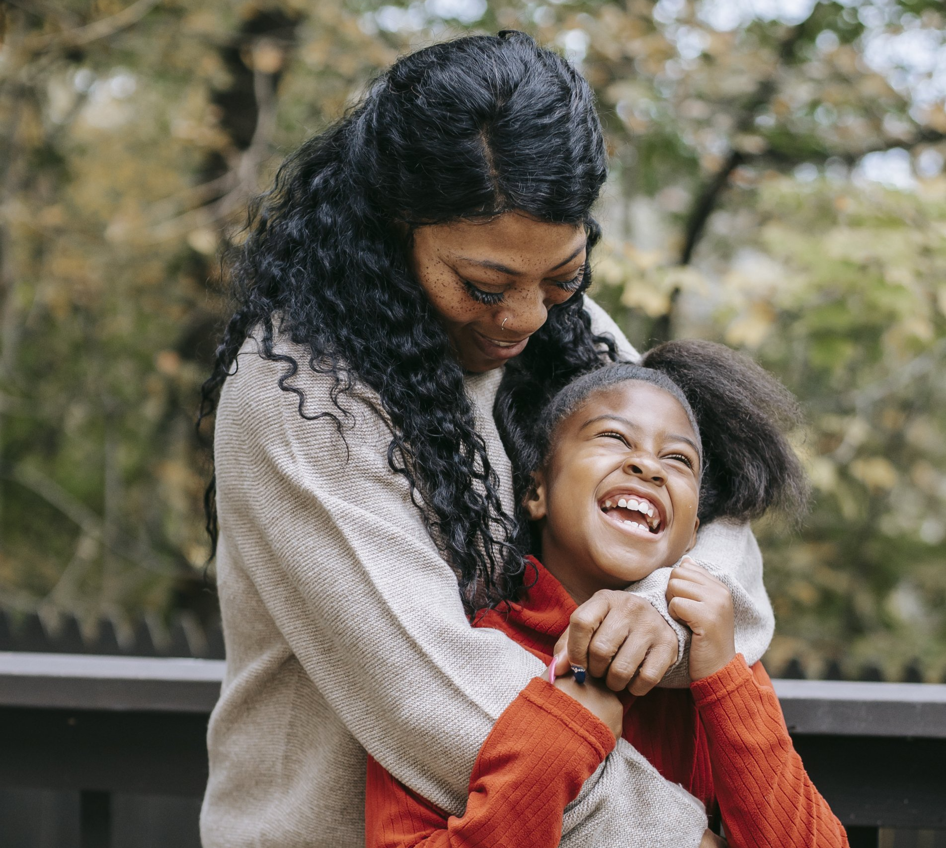 Parent and young child hugging happily