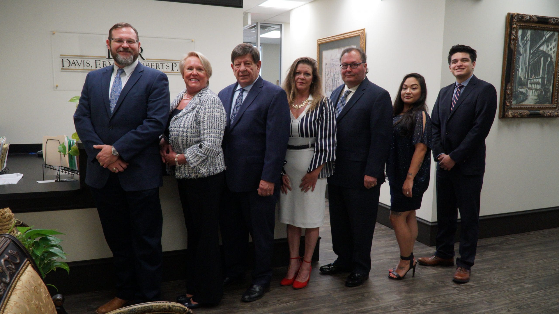 A group of people in suits and ties are standing next to each other in a room.