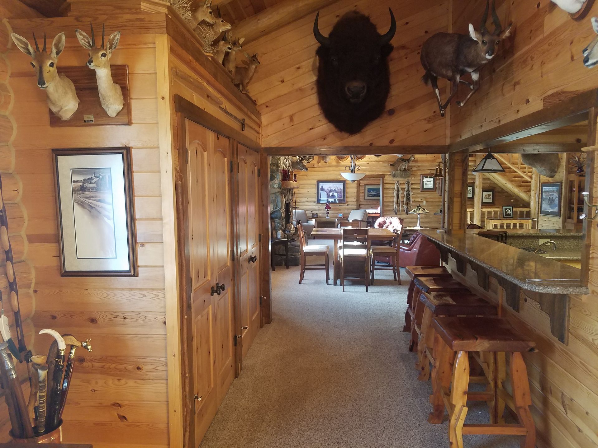 A hallway in a log cabin with stuffed animals on the walls