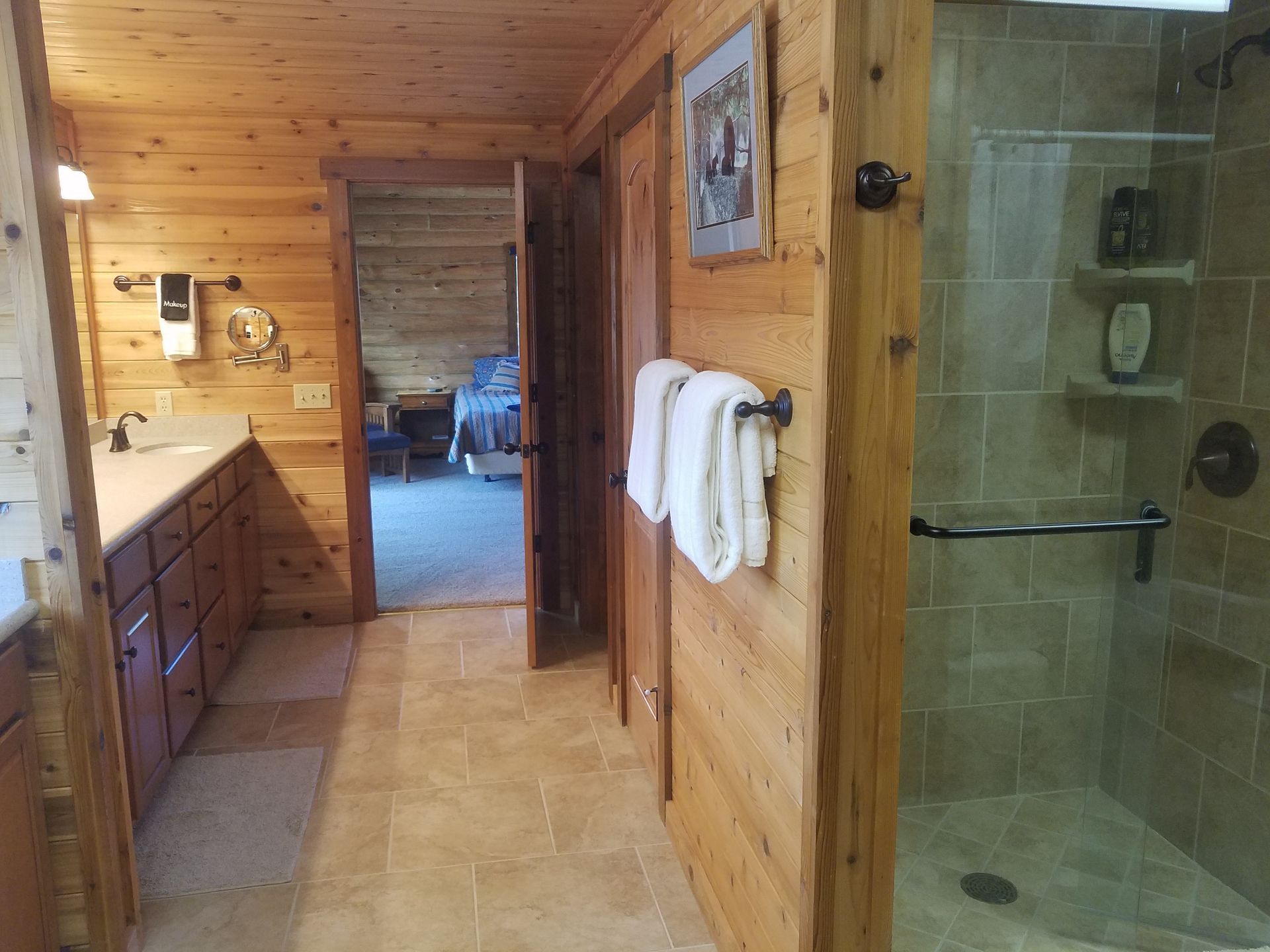 A bathroom in a log cabin with a walk in shower.