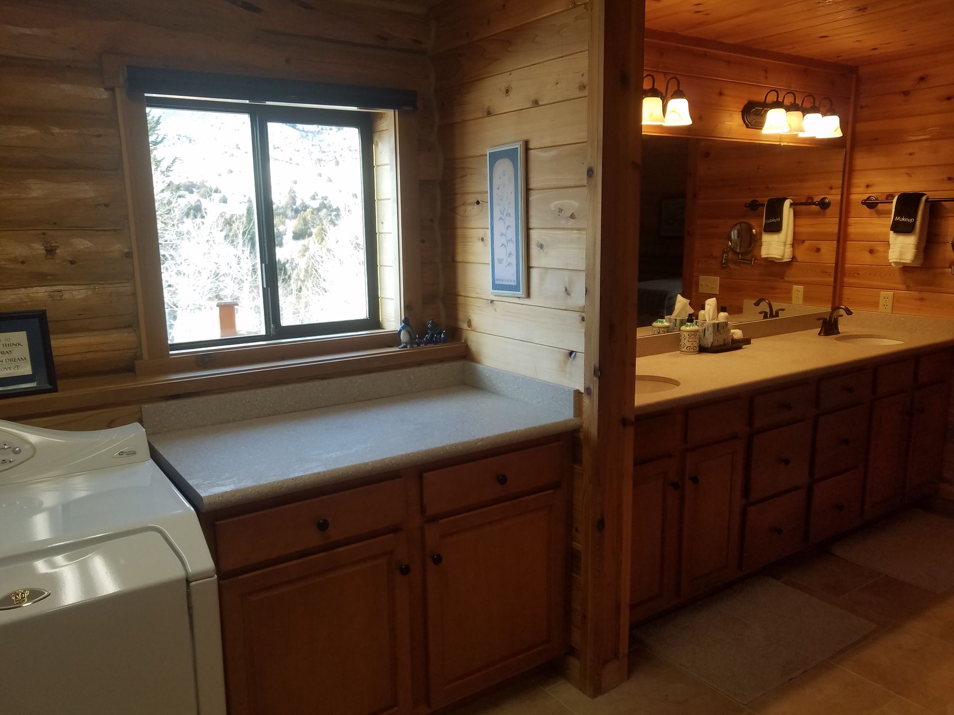 A laundry room in a log cabin with a washer and dryer