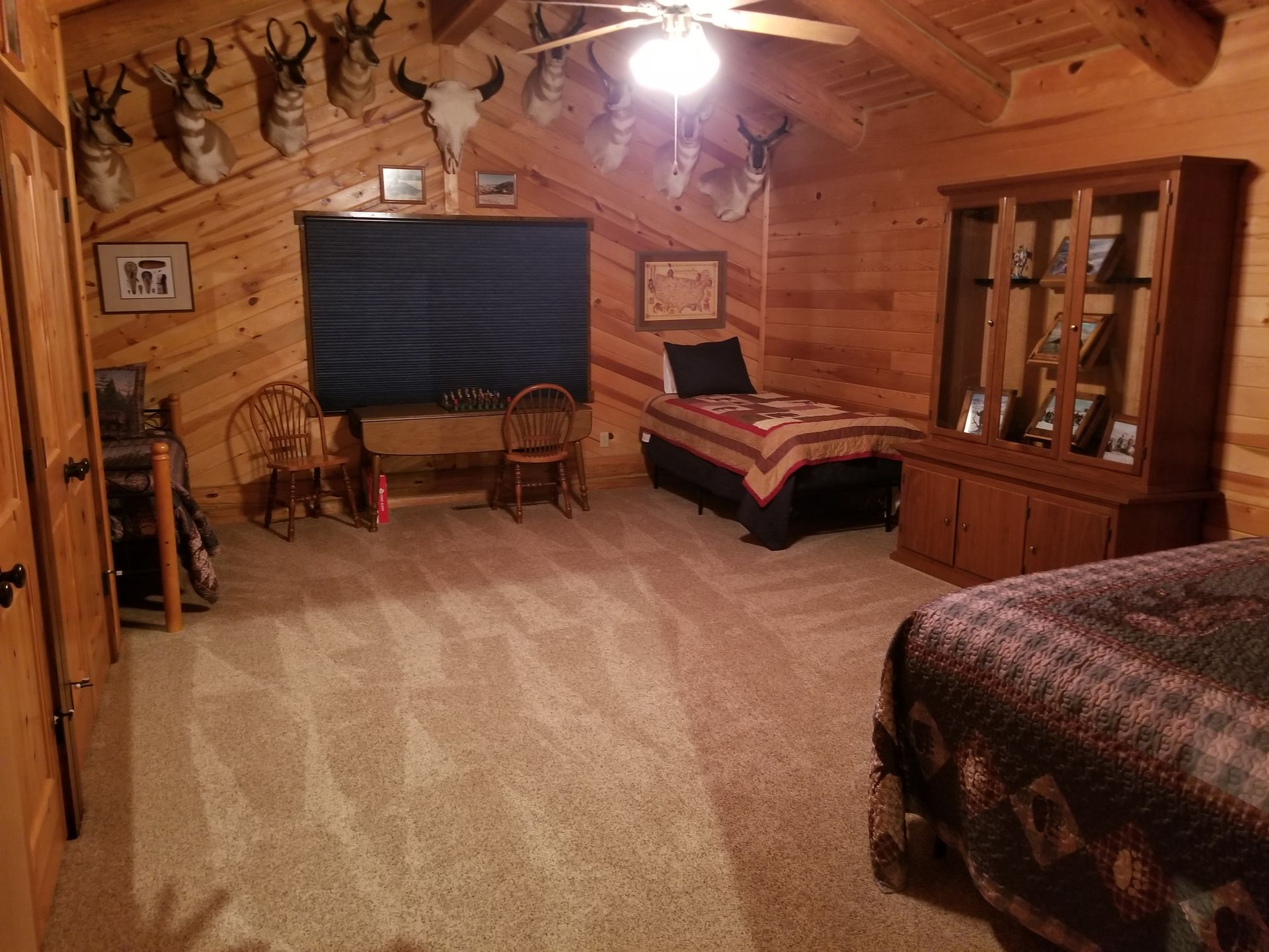 A bedroom in a log cabin with a bed and a desk