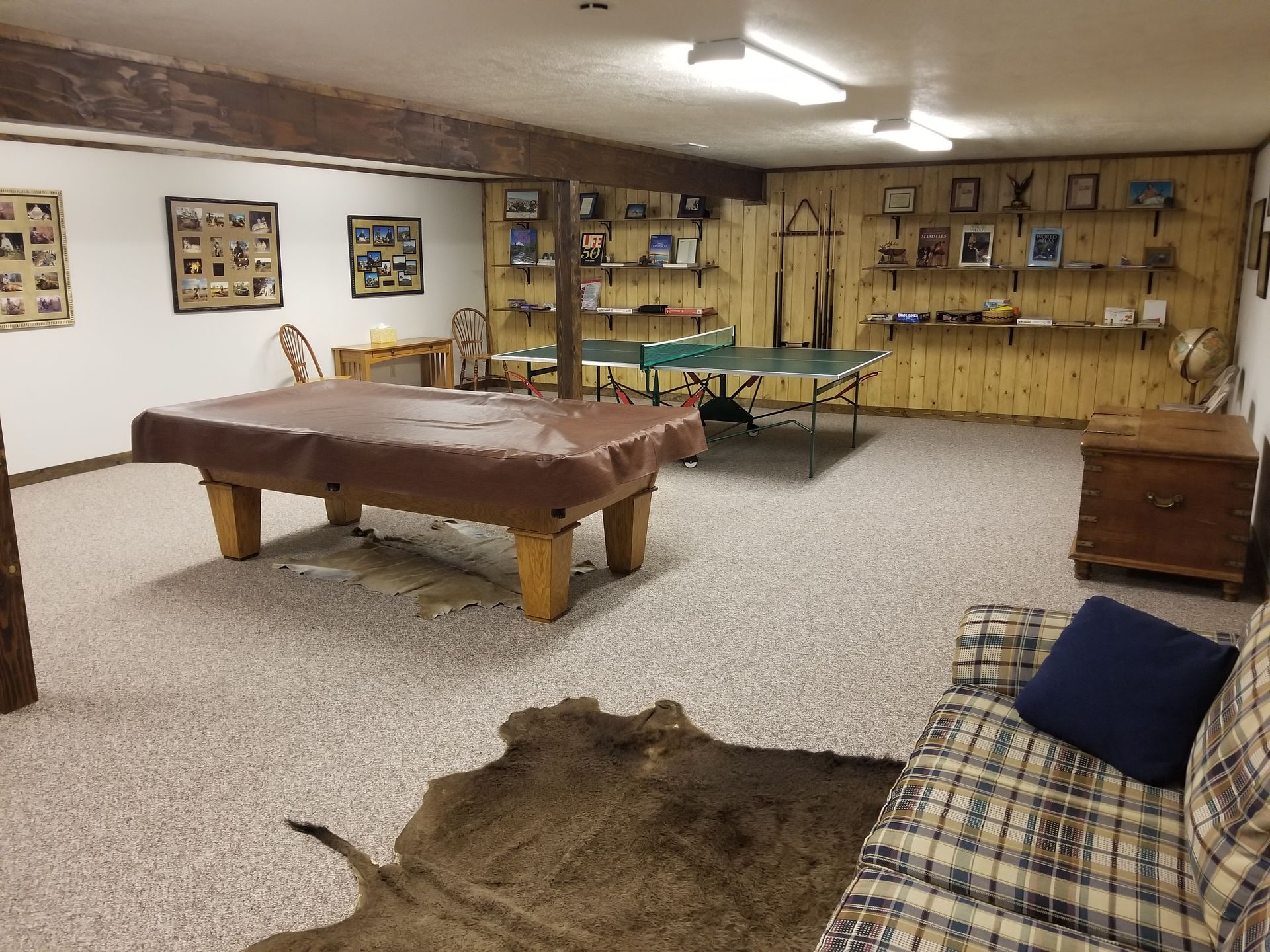 A game room with a pool table and ping pong table