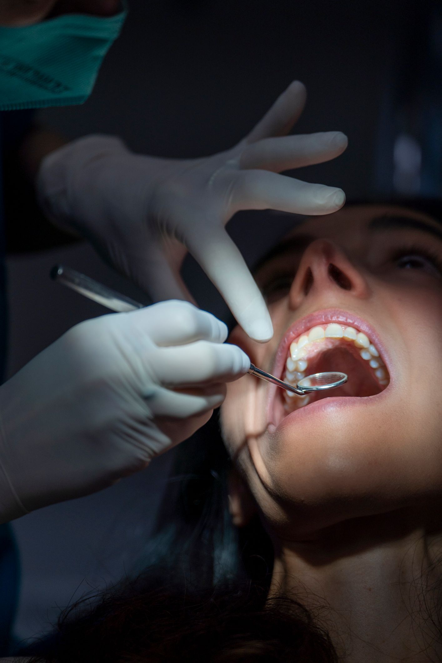 Dental Patient Checking her Teeth in a Mirror