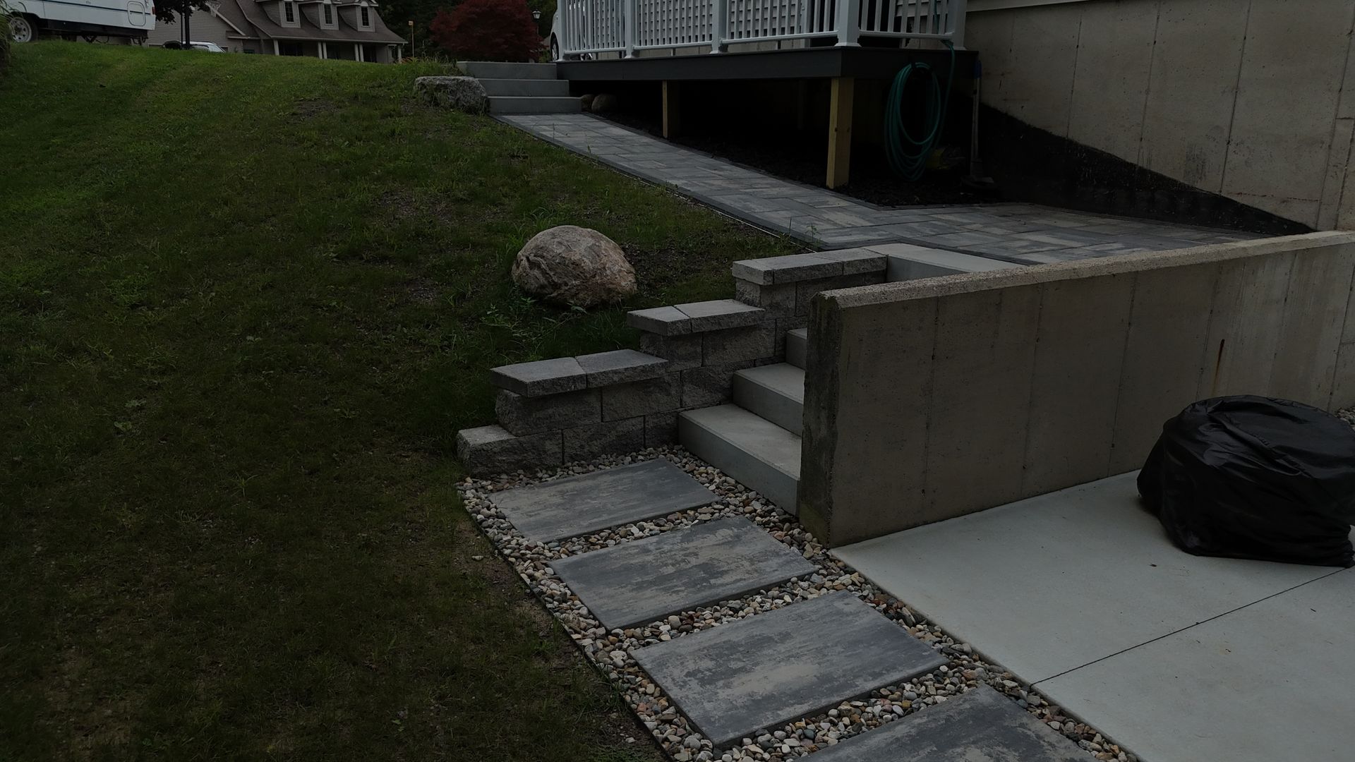 Beacon Hill Paver walkway with steps leading to a deck, set in a grassy backyard.