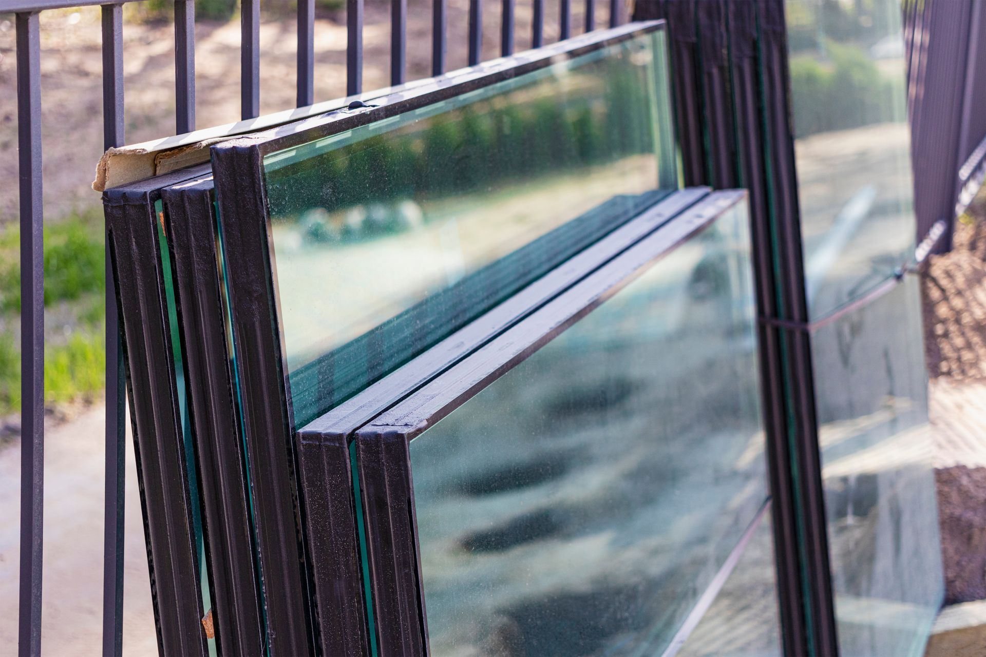Sealed glass window units stacked upright in storage for a glass installation project