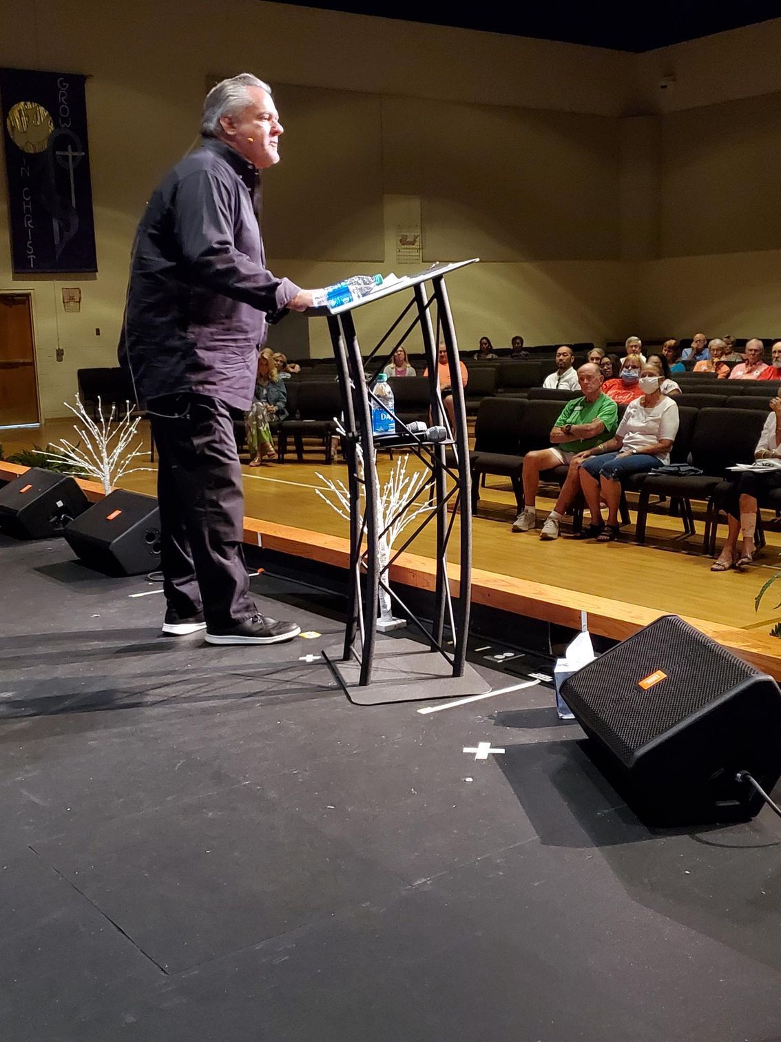 Speaker on stage at conference, with “Welcome Dan O’Shea” displayed on large screen behind him.