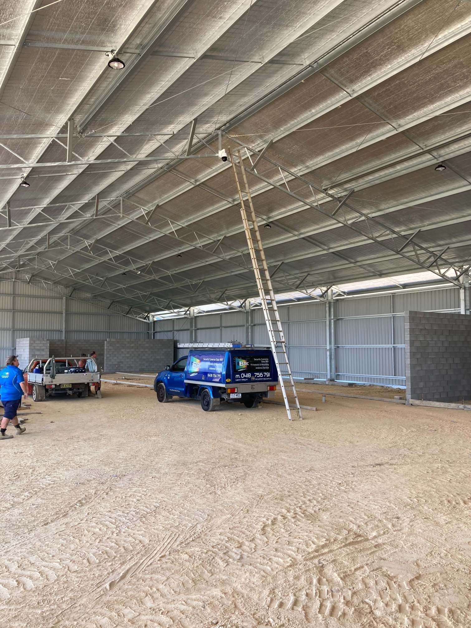Inside a Large, Open-sided Shed With a Ladder, a Blue Truck, and People — BRC Antenna Service 1 In Banora Point, NSW
