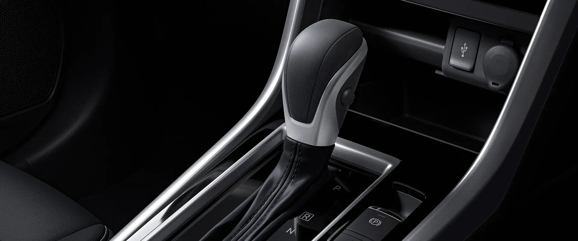 Interior car detail showing a gear shift lever, power outlets, and surrounding console.