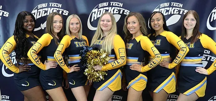A group of cheerleaders are posing for a picture.