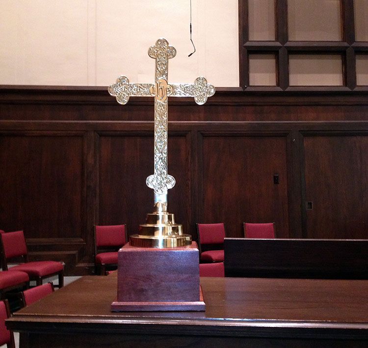 A cross is sitting on a wooden table in a church
