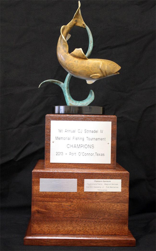 A wooden trophy with a statue of a fish on top