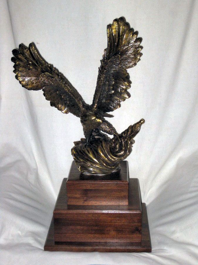 A statue of an eagle on a wooden base