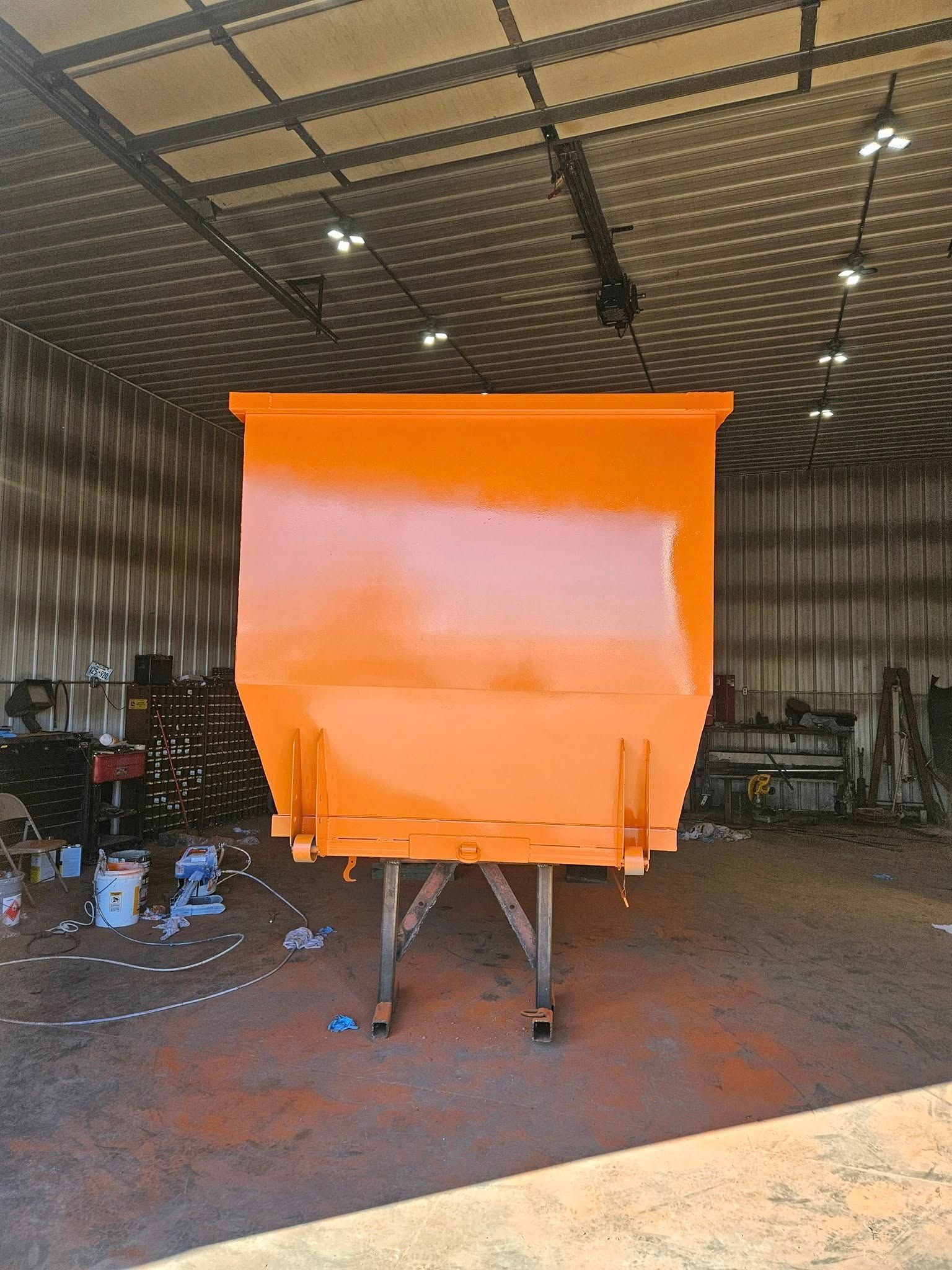 Bright orange metal structure on a stand inside a large industrial workshop