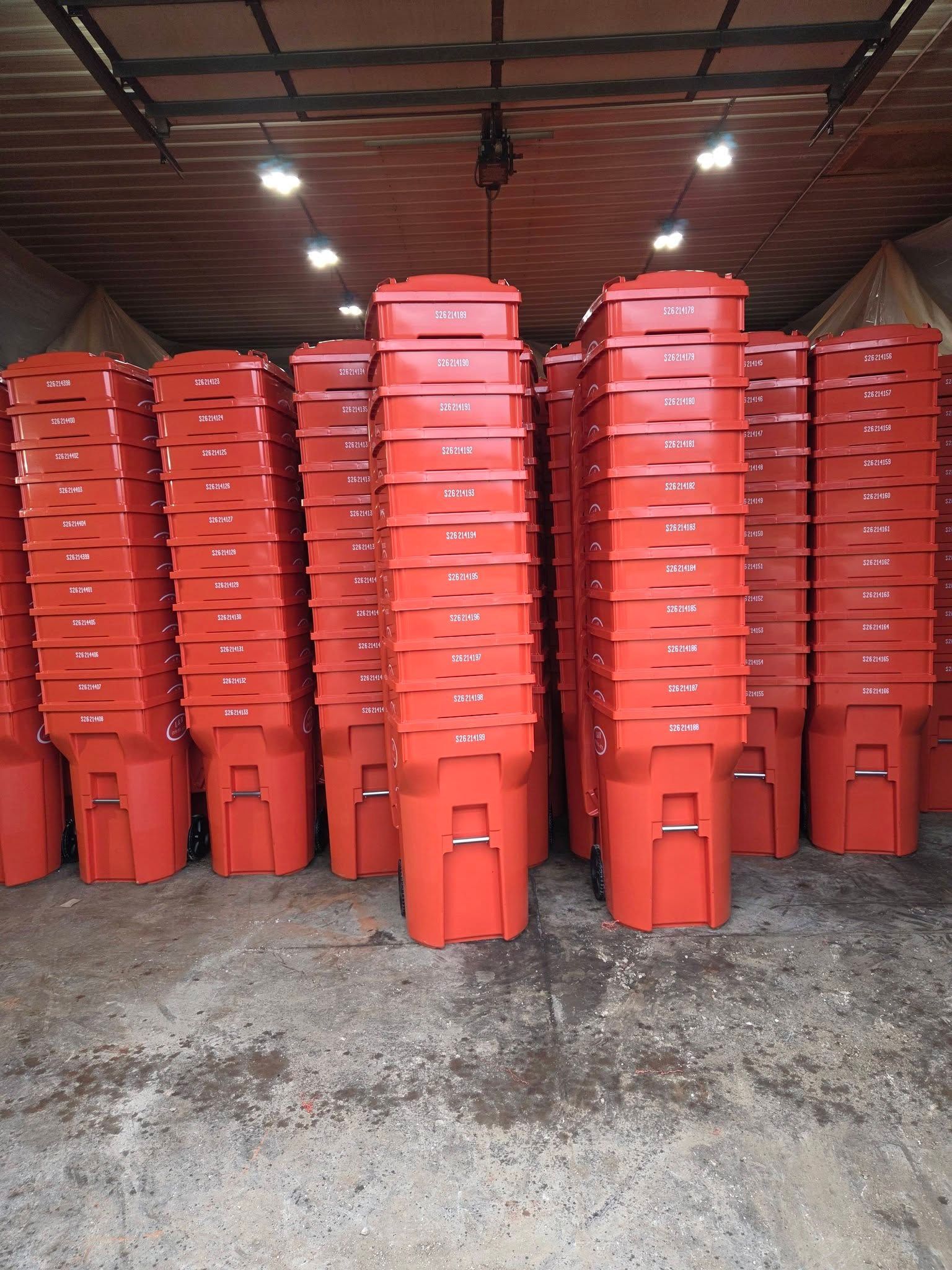 Stacks of red plastic bins piled inside a warehouse