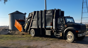 White pickup truck towing an orange utility trailer on a grassy field under a clear blue sky