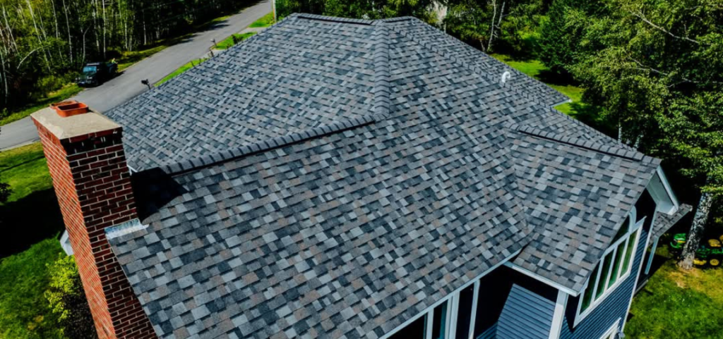 An aerial view of a house with a gray roof and a chimney.