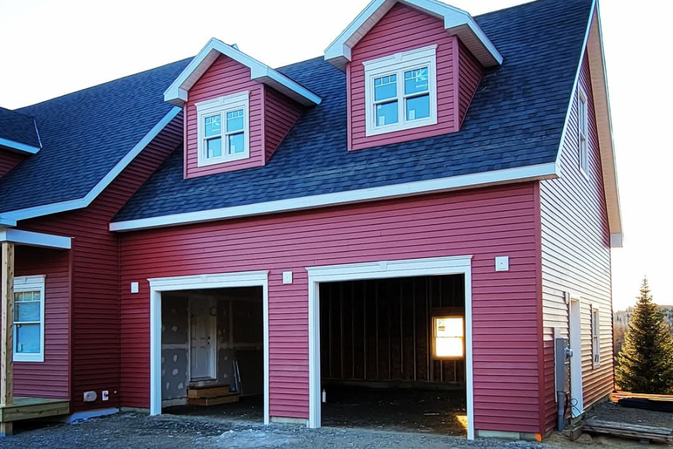 A red house with a garage underneath it