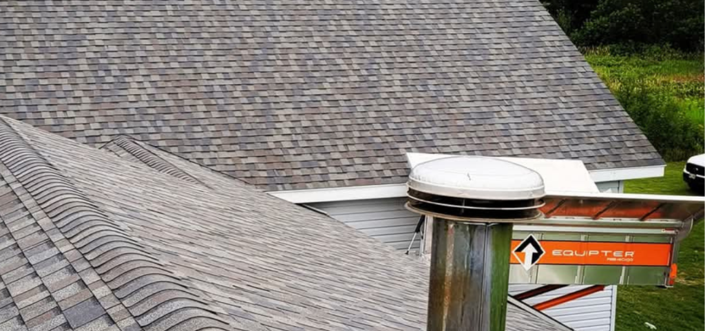 A roof with a chimney on it and a sign in front of it.