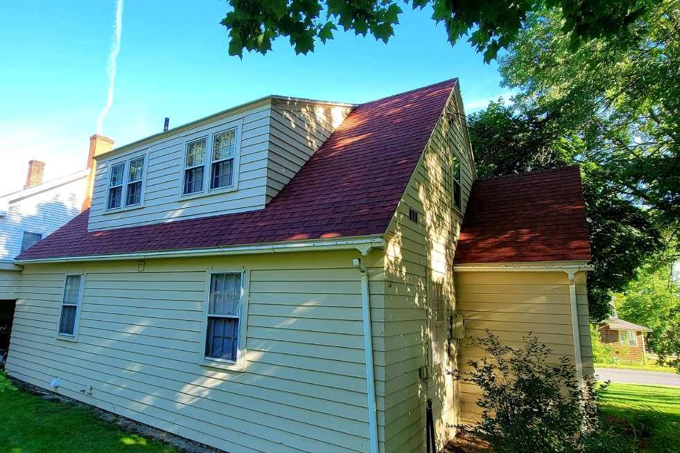 A house with a red roof and a white siding