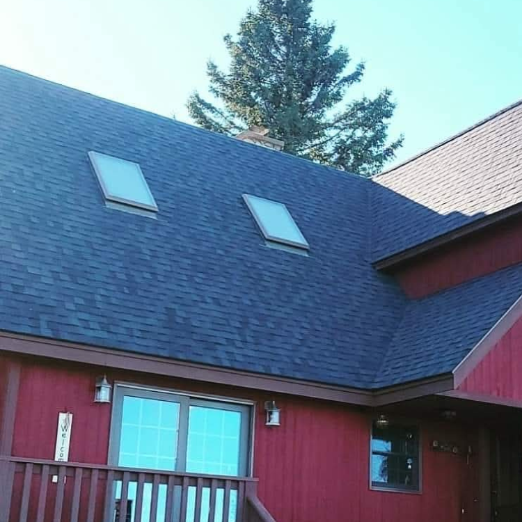 A red house with two skylights on the roof