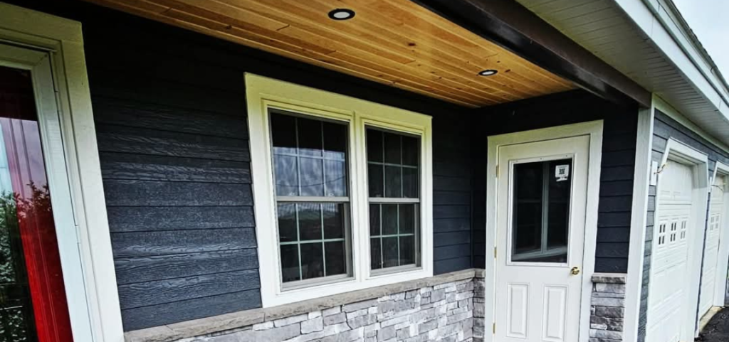 A black and white house with a white door and windows.