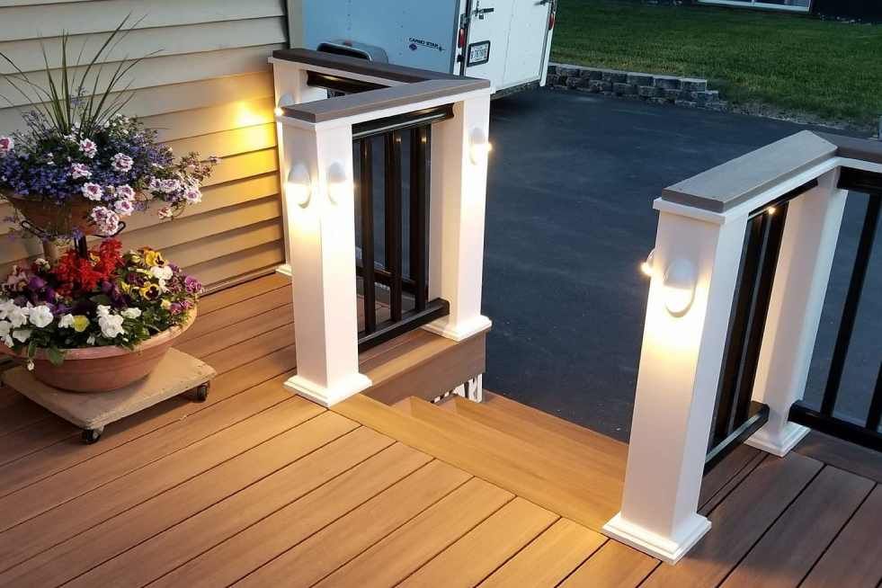 A wooden deck with a planter of flowers on it.