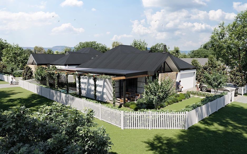 A modern house with a white picket fence, greenery, and dark roof under a cloudy sky — Stark Building & Constructions In Berry, NSW