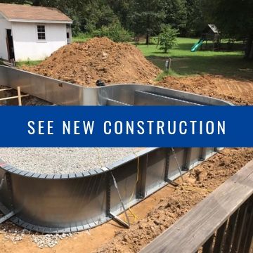 An in-ground swimming pool under construction with metal walls set in a backyard excavation.