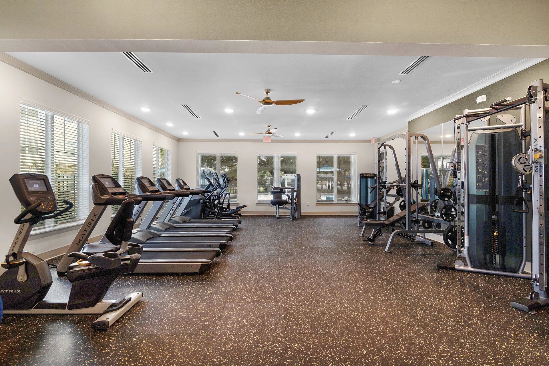 A large gym with a lot of treadmills and exercise bikes.