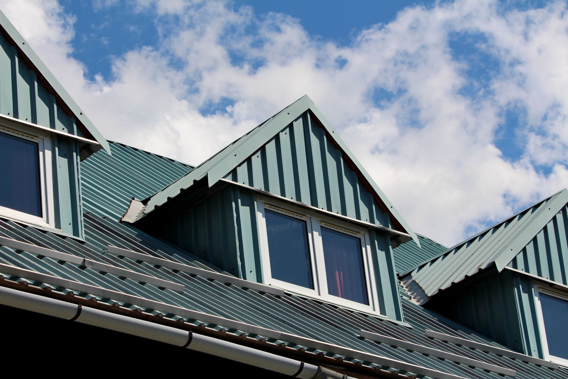 A row of houses with green roofs and white windows