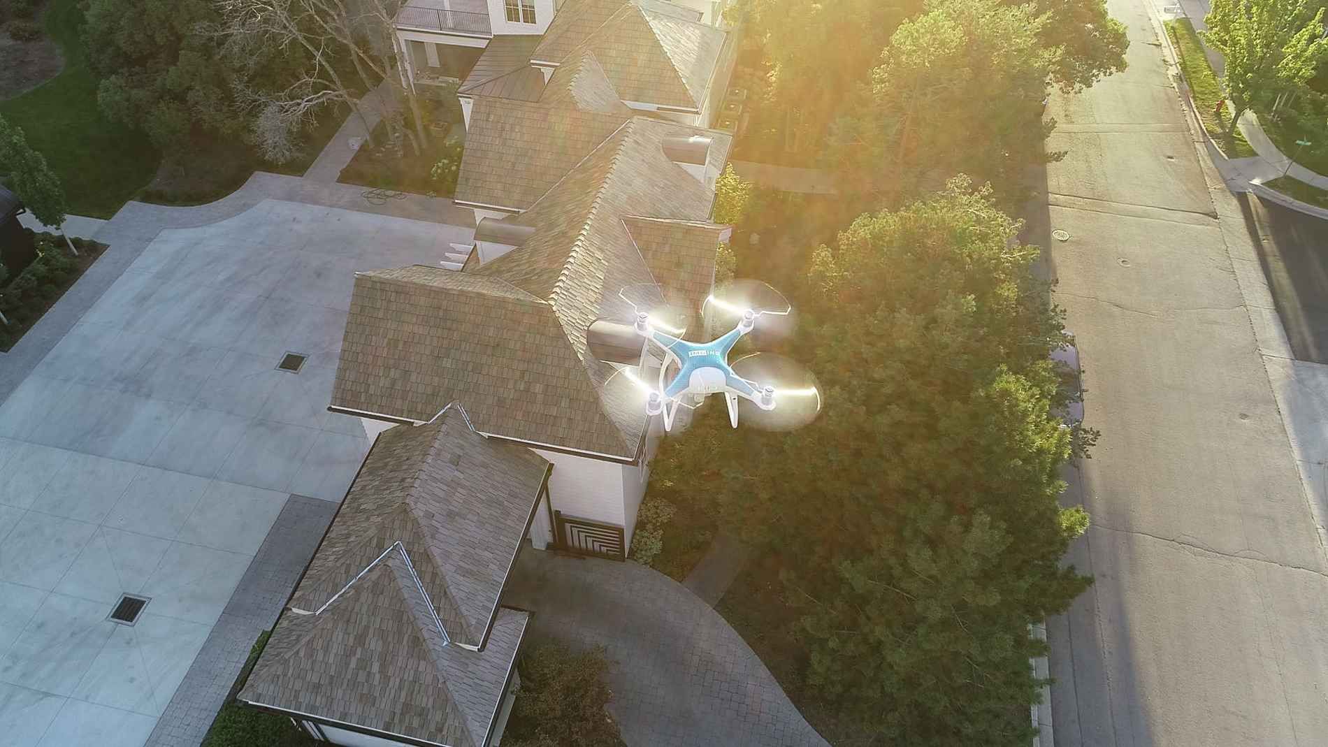 An aerial view of a drone flying over a residential neighborhood.