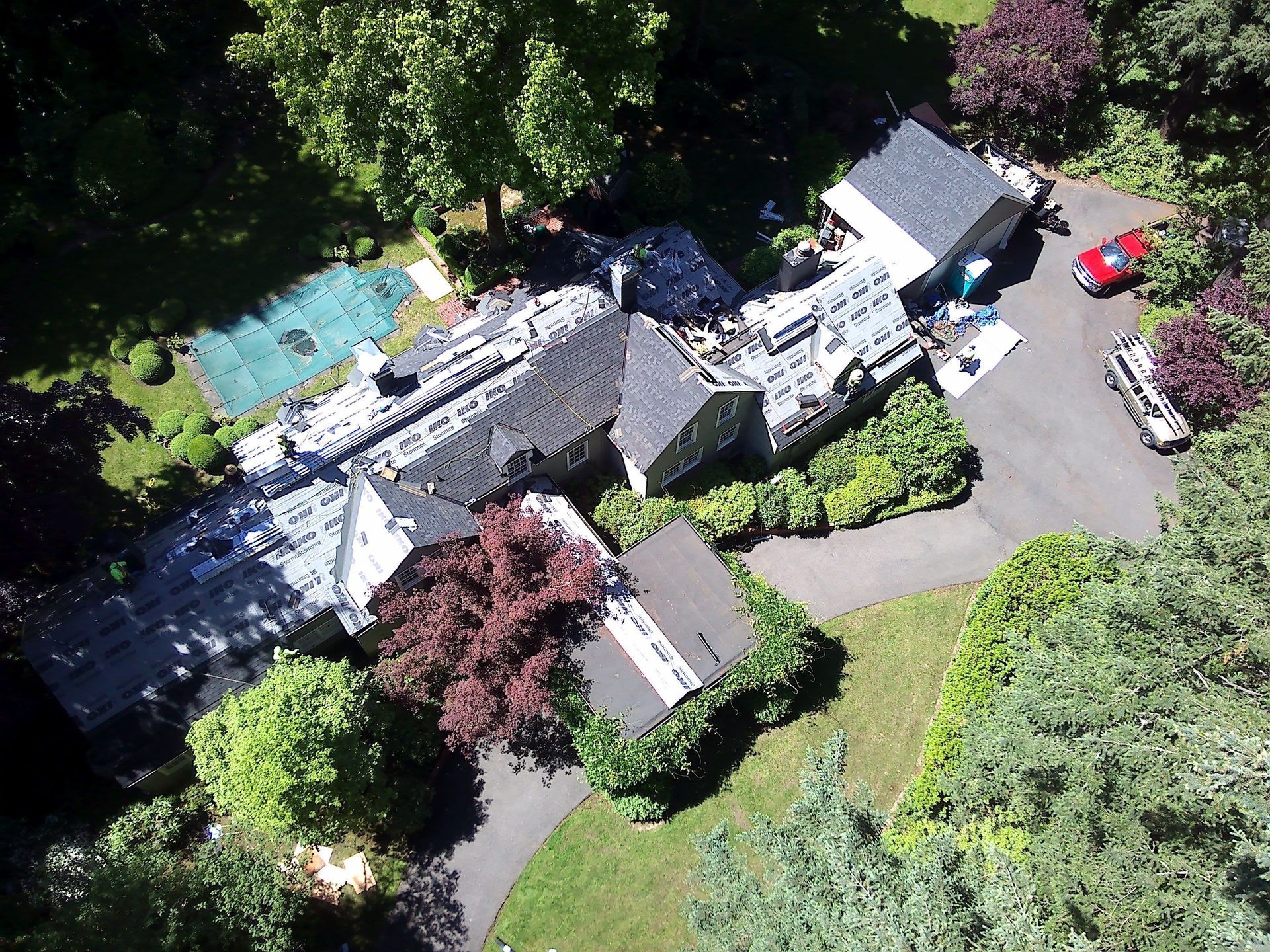 Modern apartment building with gray and brown siding, balconies, and large windows