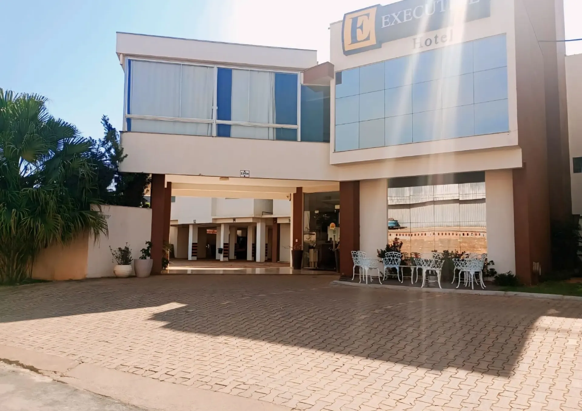 Um grande edifício com muitas janelas e cadeiras na frente dele-Executive-Hotel-MT