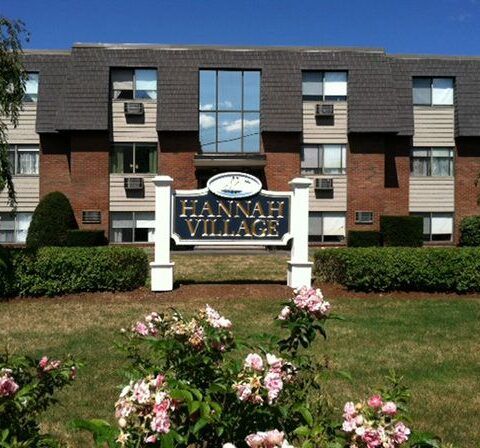 Hannah Village apartment building with landscaped lawn and flower bed