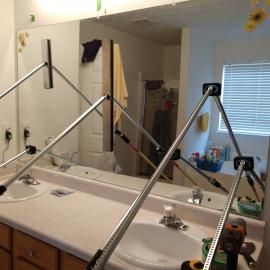 A measuring tool set up on a bathroom counter in front of a mirror to capture dimensions.