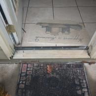 A doorway with a tiled floor entry, a light-colored mat that says 