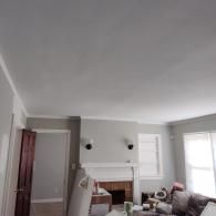 A gray living room with white trim, a fireplace, and a doorway, viewed from a low angle.
