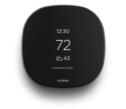 A black thermostat with a temperature of 72 degrees is sitting on a white surface.