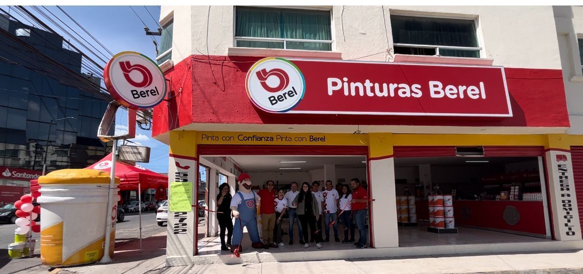Un coche blanco está aparcado frente a una tienda de pintura berel.